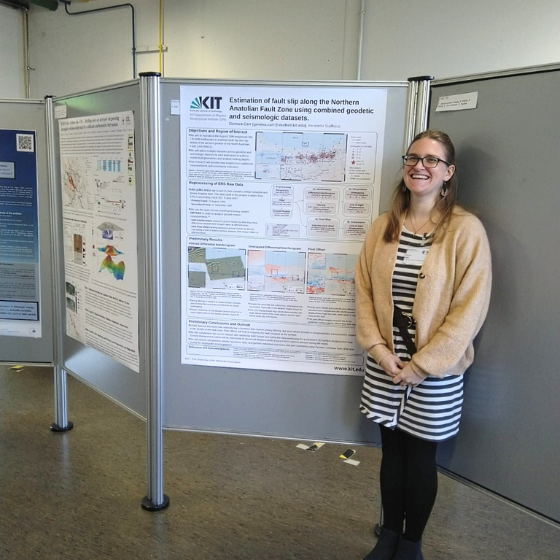 Frau steht neben wissenschaftlichem Poster-Standort in Ausstellungshalle.